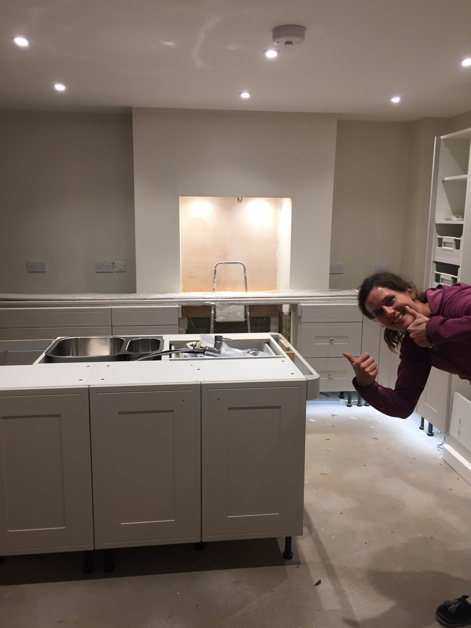 Sally beside the kitchen she was building